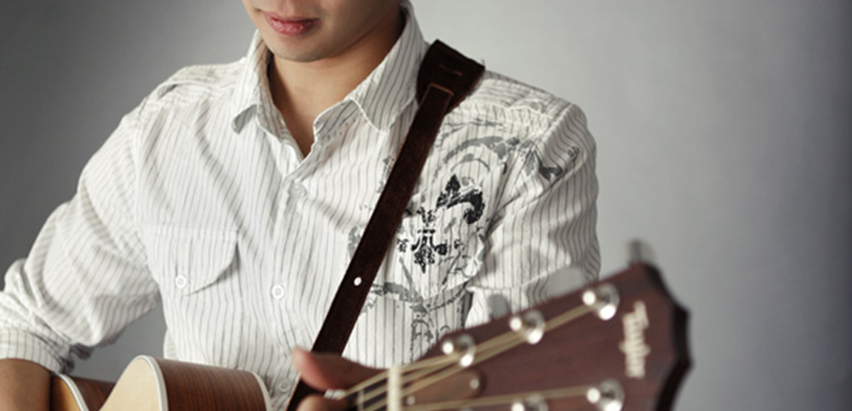 Jony C standing with a guitar
